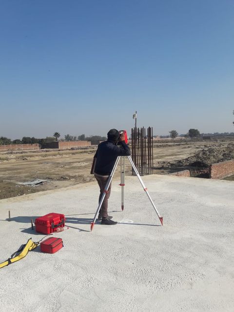 Site engineer surveying Phase 2 with a total station